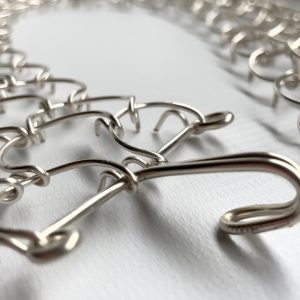 A three link, 1mm gauge full-length waist metal cilice with metal fastener