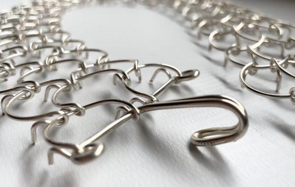 A three link, 1mm gauge full-length waist metal cilice with metal fastener
